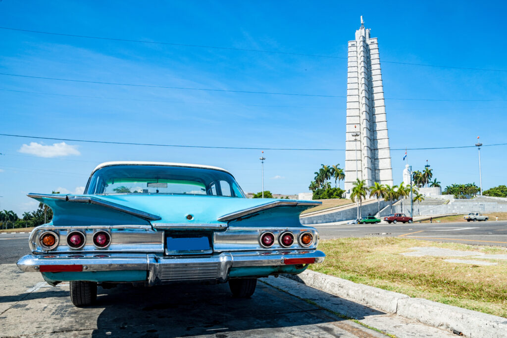 A pale blue American made classic car sitting in front of Jose Marti' Memorial in Havana, Cuba. Photograph Taken by Emilio Dellepiane ManyMoonsPhoto.com Licensed through Adobe Stock CC https://stock.adobe.com/images/auto-a-cuba/100374692?prev_url=detail