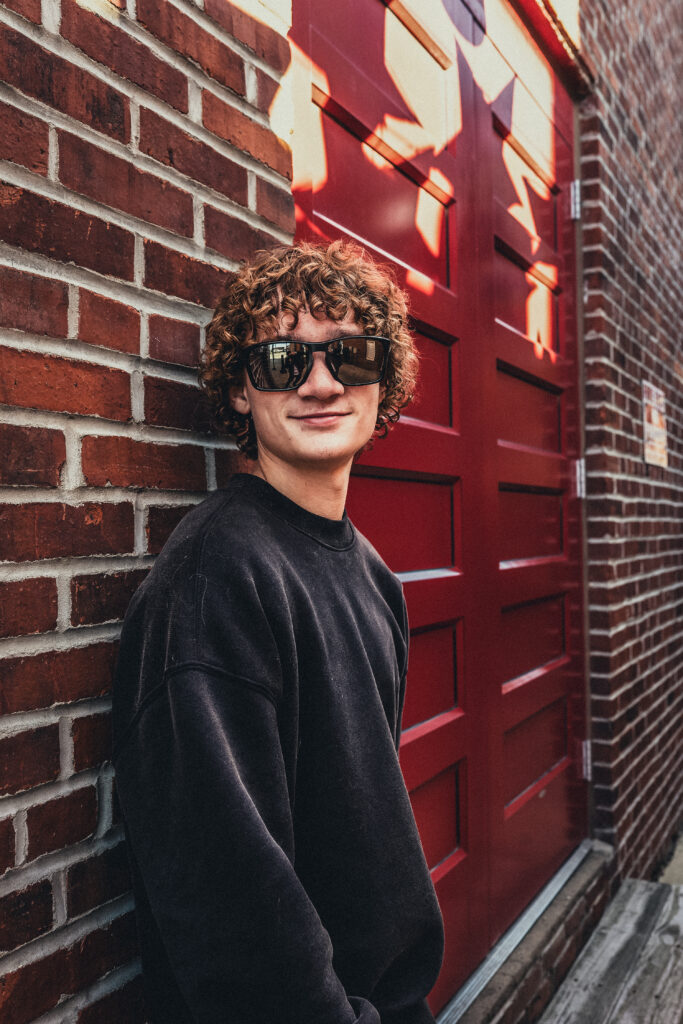 Portrait photo of a boy with curly hair in black.