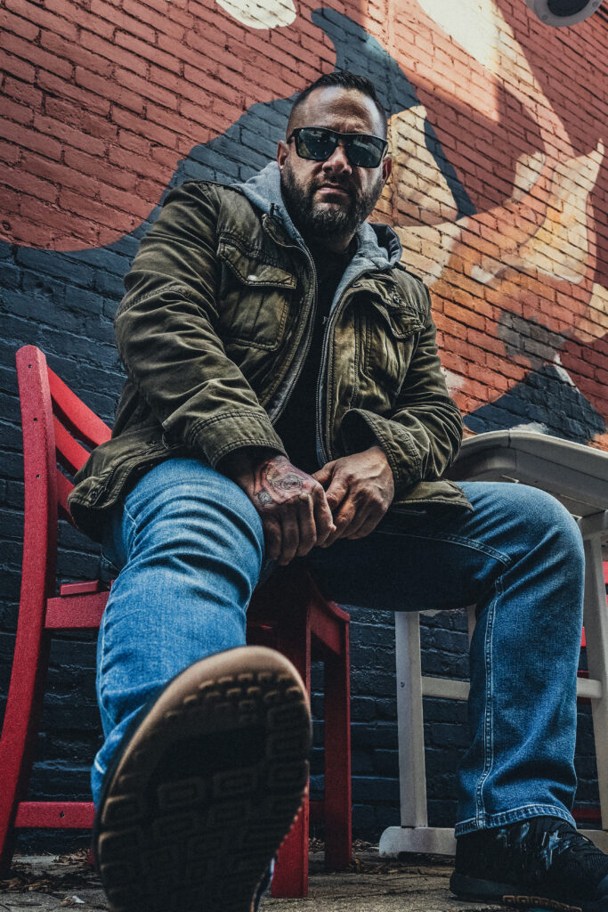 Self portrait against brick wall.
